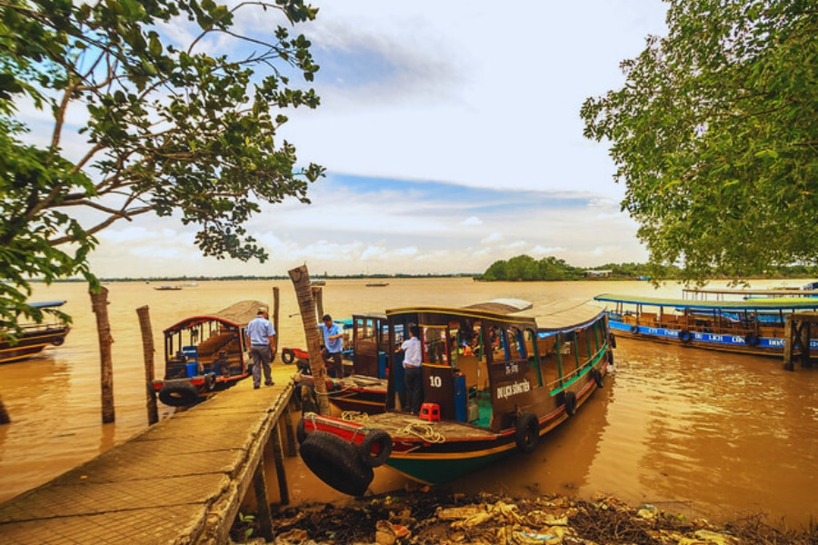 Mekong Delta river cruise boats waiting at riverside pier by Auasia Travel tours